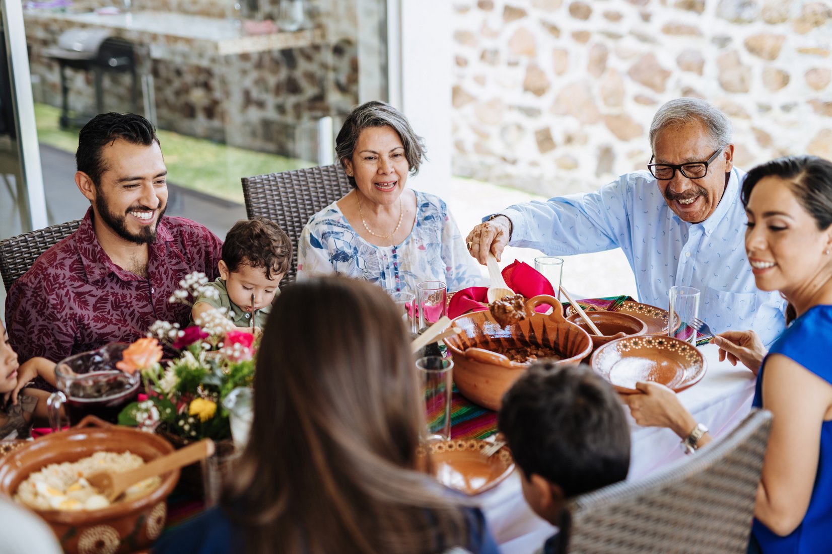 Multi generation Latin American family having family lunch together in summer